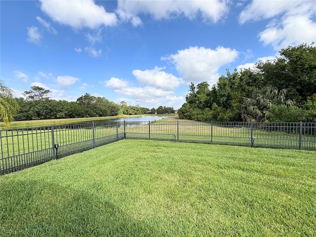 view of yard featuring a water view and a fenced backyard