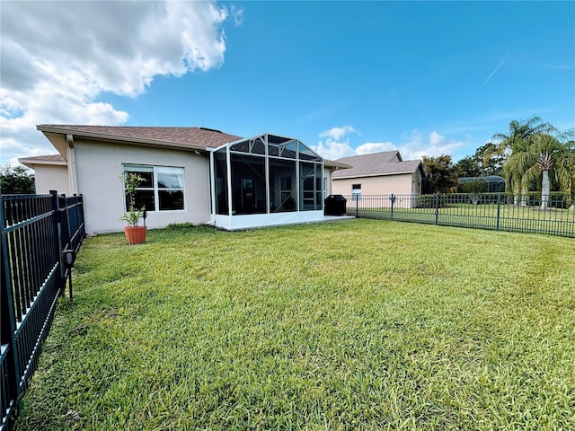back of property with a lawn, stucco siding, and a fenced backyard
