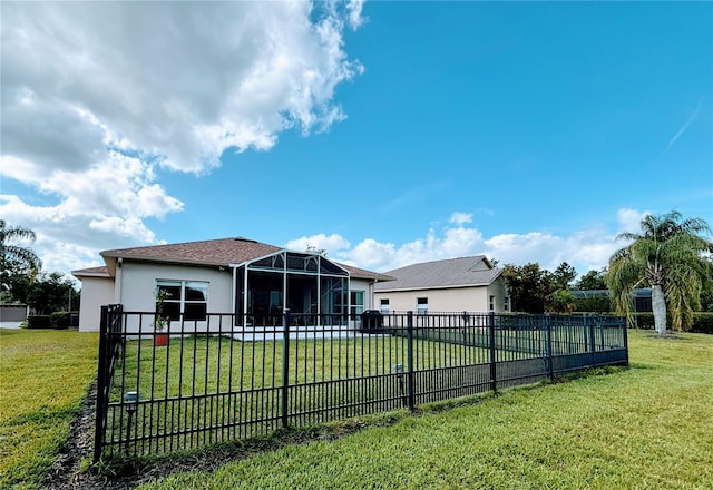 rear view of house featuring a fenced backyard, stucco siding, and a yard