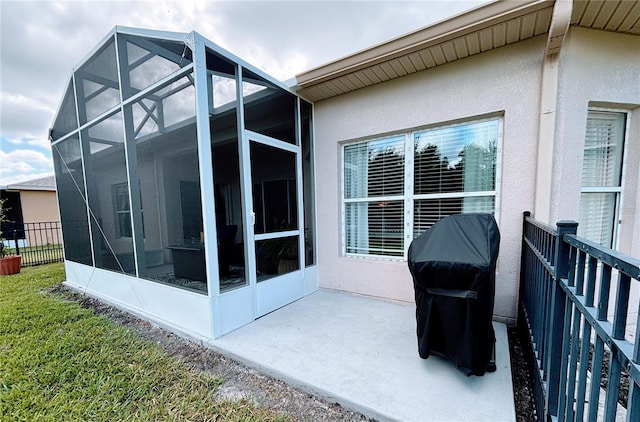 rear view of property featuring fence, a lanai, stucco siding, and a patio area
