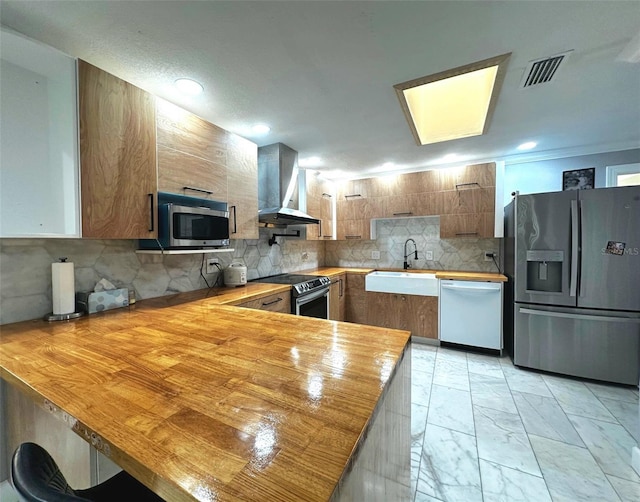 3328 Wax Berry Ct, Windermere, FL 34786 - kitchen with visible vents, appliances with stainless steel finishes, tasteful backsplash, a peninsula, and wall chimney exhaust hood