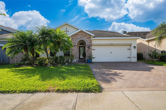 view of front of house featuring decorative driveway, an attached garage, a front yard, and stucco siding