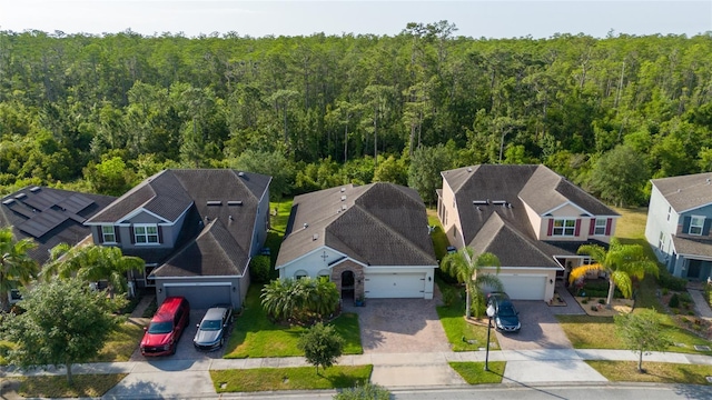 drone / aerial view featuring a residential view and a forest view