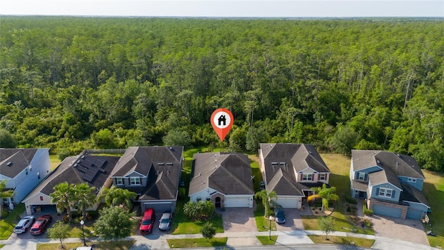 drone / aerial view with a residential view and a wooded view