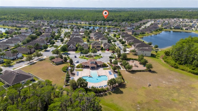 birds eye view of property with a wooded view, a water view, and a residential view
