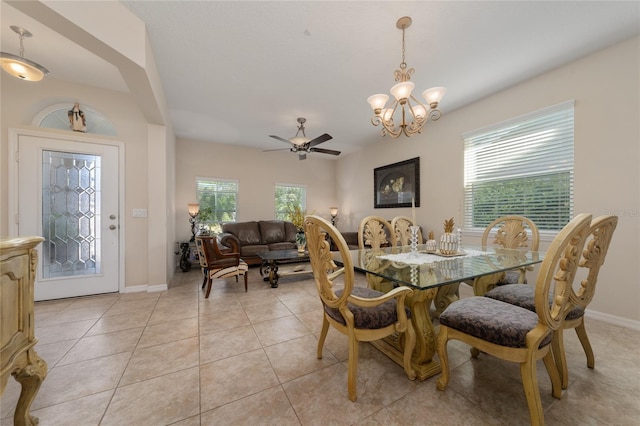 dining area with baseboards, light tile patterned floors, and ceiling fan with notable chandelier