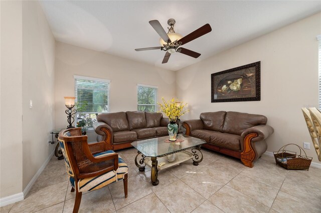 living area featuring baseboards, a ceiling fan, and light tile patterned flooring