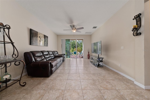 living room with baseboards, ceiling fan, visible vents, and light tile patterned floors
