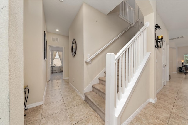 staircase featuring tile patterned floors, a wealth of natural light, and visible vents