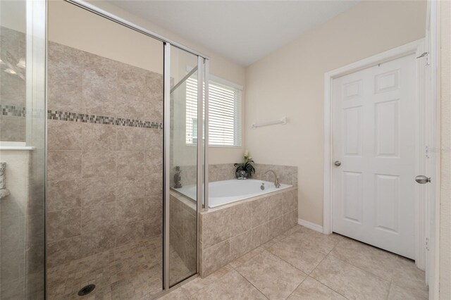 bathroom with tile patterned flooring, a shower stall, and a bath
