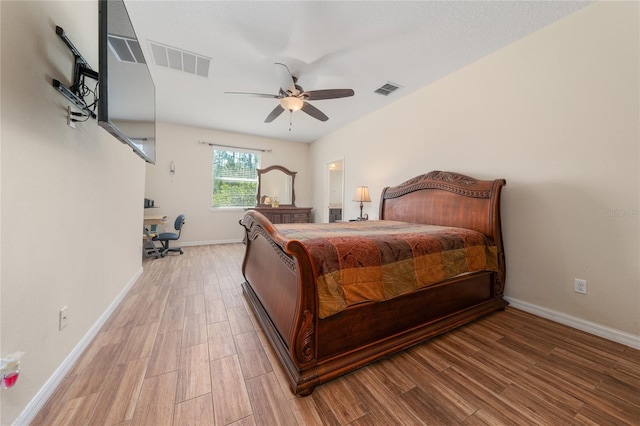 bedroom featuring baseboards, wood finished floors, and visible vents