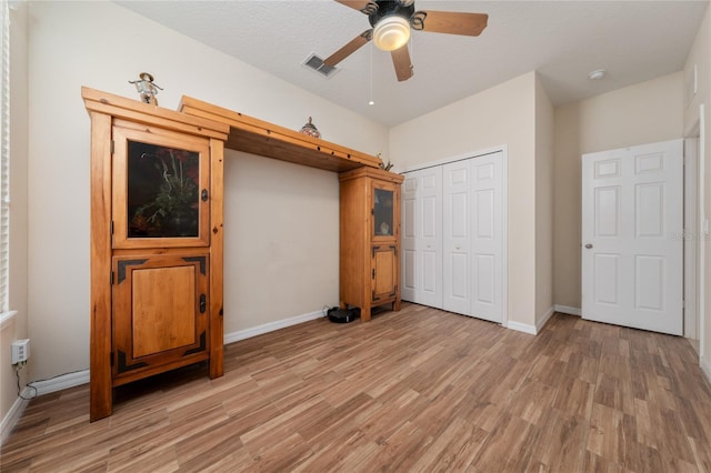 unfurnished bedroom featuring a closet, baseboards, visible vents, and light wood-style floors