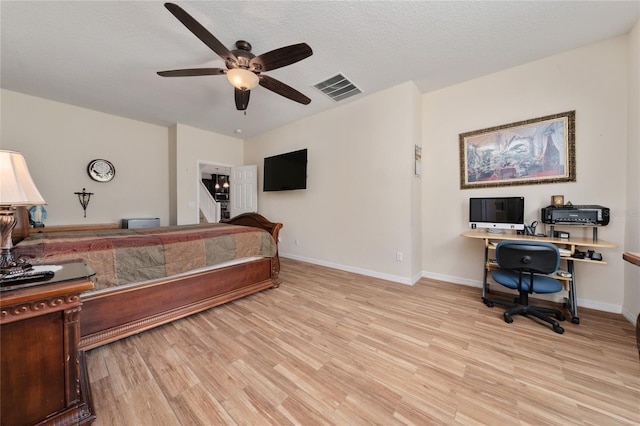 bedroom featuring visible vents, a textured ceiling, baseboards, and light wood-type flooring