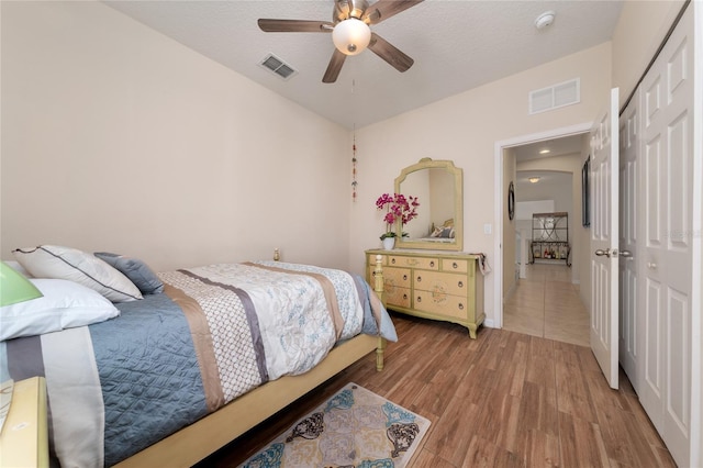 bedroom featuring a ceiling fan, a closet, light wood-type flooring, and visible vents