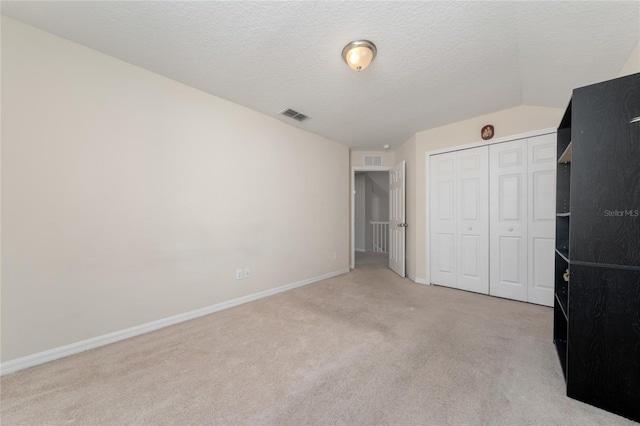 unfurnished bedroom featuring baseboards, carpet, a closet, and visible vents
