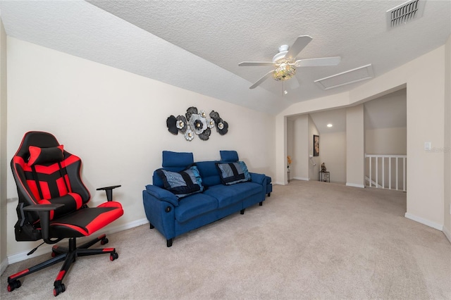living room with attic access, a textured ceiling, visible vents, vaulted ceiling, and carpet