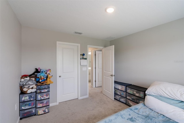 carpeted bedroom featuring baseboards and visible vents