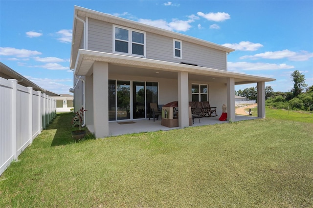 back of property featuring a yard, fence, a patio area, and stucco siding