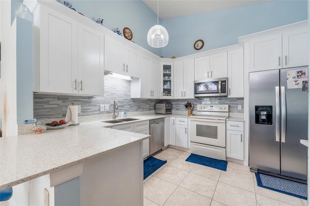 98 Lakepointe Cir, Kissimmee, FL 34743 - kitchen with tasteful backsplash, glass insert cabinets, appliances with stainless steel finishes, a sink, and light tile patterned flooring