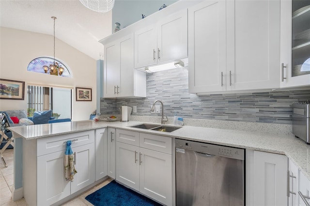 98 Lakepointe Cir, Kissimmee, FL 34743 - kitchen with a sink, backsplash, vaulted ceiling, white cabinetry, and stainless steel dishwasher