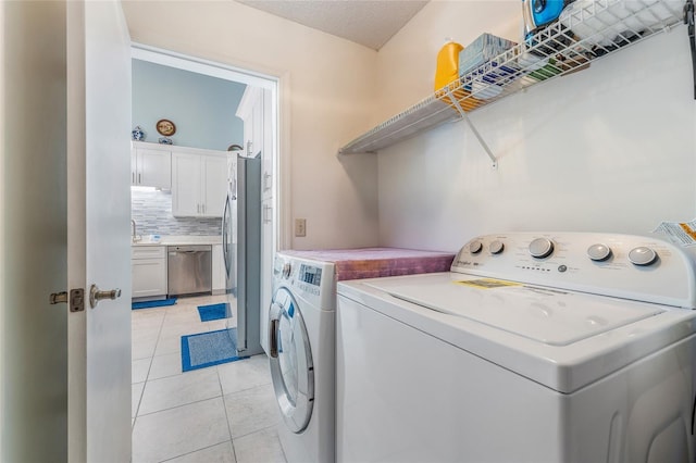 98 Lakepointe Cir, Kissimmee, FL 34743 - laundry room with light tile patterned floors, washing machine and clothes dryer, and laundry area