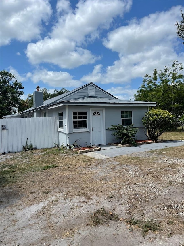 view of front of house with fence and a chimney