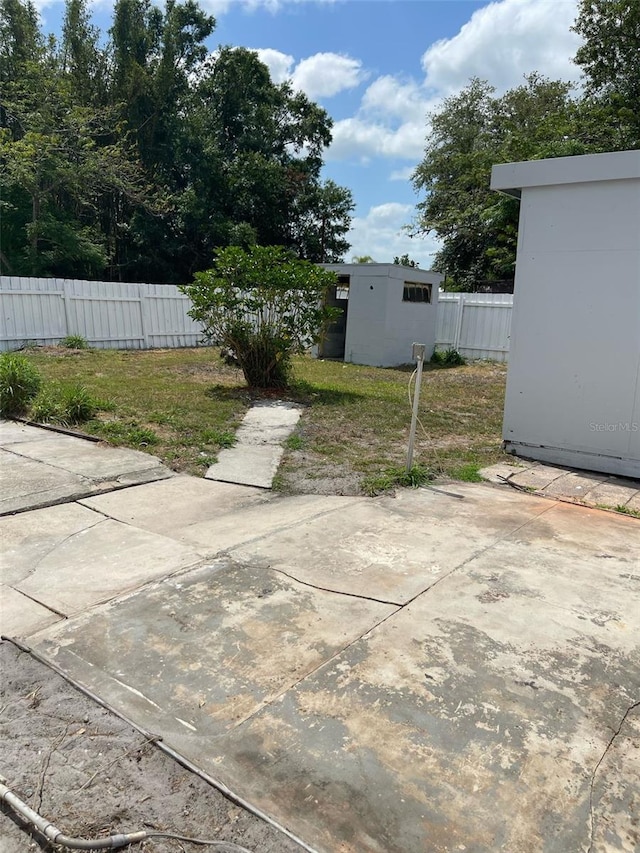 view of patio with fence and an outbuilding