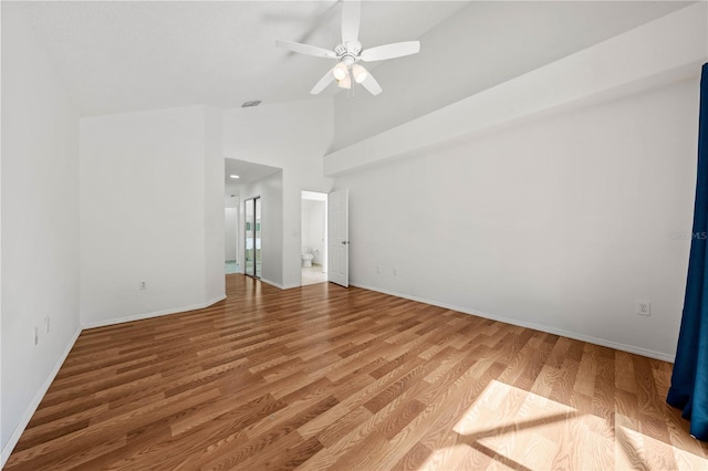 spare room with visible vents, baseboards, ceiling fan, high vaulted ceiling, and light wood-type flooring
