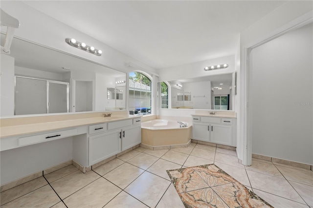 bathroom featuring a sink, a stall shower, a bath, and two vanities