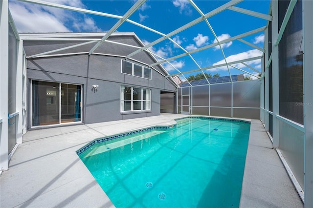 outdoor pool with glass enclosure and a patio