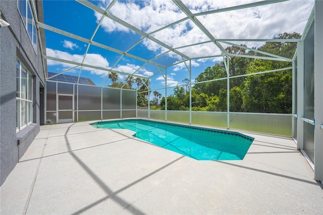 pool featuring a patio and glass enclosure