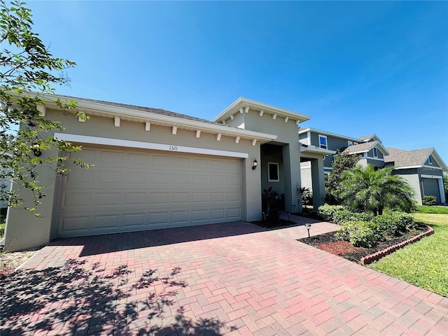 1321 Yorkdale Rd, Davenport, FL 33837 - view of front of home with stucco siding, an attached garage, and decorative driveway