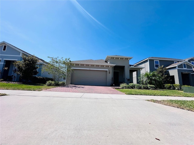 1321 Yorkdale Rd, Davenport, FL 33837 - prairie-style house with an attached garage, stucco siding, and decorative driveway