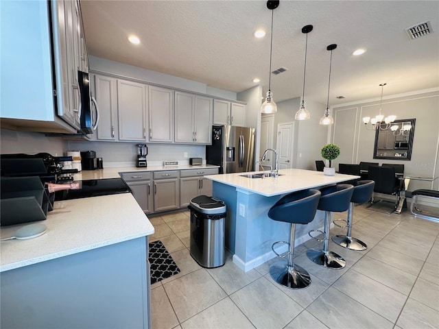 1321 Yorkdale Rd, Davenport, FL 33837 - kitchen with visible vents, a breakfast bar area, gray cabinets, a sink, and stainless steel appliances