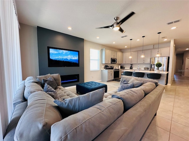 1321 Yorkdale Rd, Davenport, FL 33837 - living room featuring ceiling fan, visible vents, light tile patterned floors, a glass covered fireplace, and recessed lighting