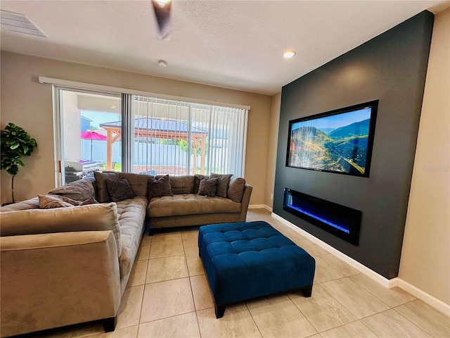 1321 Yorkdale Rd, Davenport, FL 33837 - living area featuring visible vents, baseboards, a glass covered fireplace, and light tile patterned floors