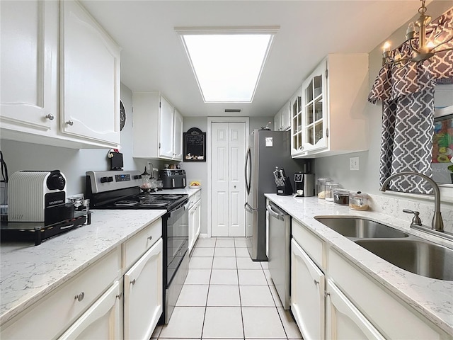 kitchen with range with electric stovetop, dishwasher, a sink, light tile patterned floors, and white cabinets