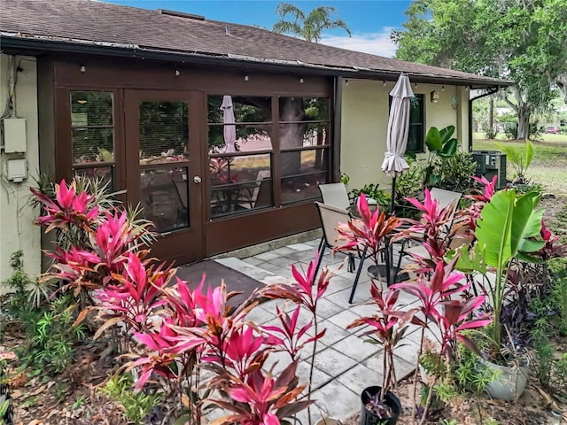 exterior space with a shingled roof, a patio, stucco siding, and french doors