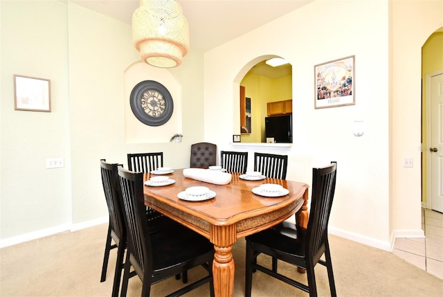 2778 Almaton Loop Unit 403, Kissimmee, FL 34747 - dining space with arched walkways, baseboards, light colored carpet, and light tile patterned flooring