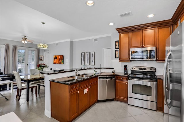 1501 Northern Harrier Way Unit 101, Kissimmee, FL 34747 - kitchen featuring brown cabinetry, a sink, a peninsula, and stainless steel appliances