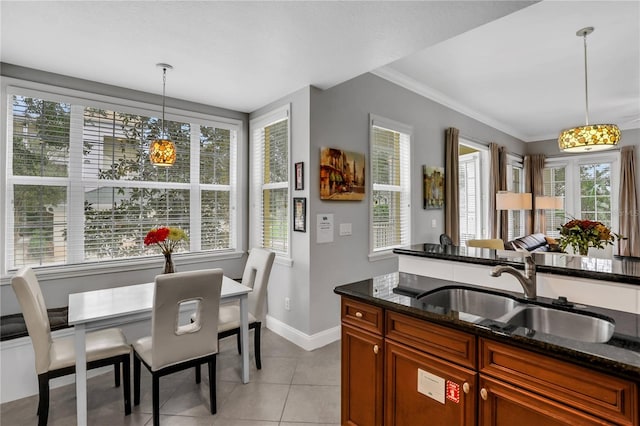 1501 Northern Harrier Way Unit 101, Kissimmee, FL 34747 - kitchen featuring baseboards, a sink, dark stone counters, and hanging light fixtures