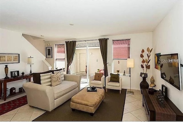 living area with baseboards and light tile patterned floors