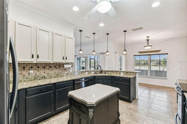 759 Glendora Rd, Kissimmee, FL 34759 - kitchen with appliances with stainless steel finishes, a sink, tasteful backsplash, healthy amount of natural light, and ornamental molding
