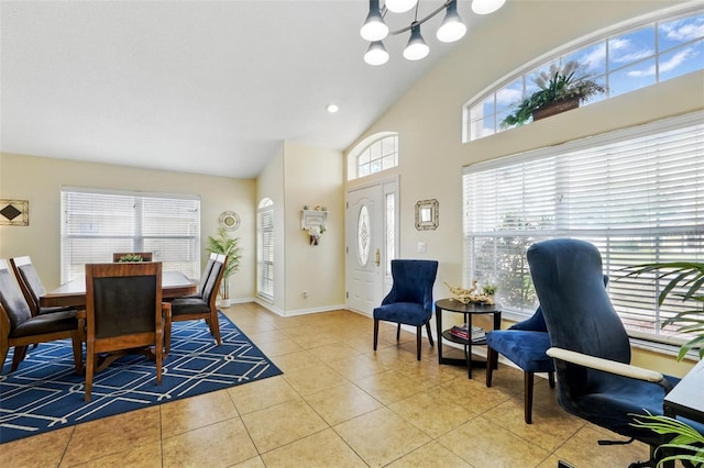dining area featuring an inviting chandelier, high vaulted ceiling, baseboards, and tile patterned floors