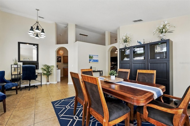 dining space with arched walkways, baseboards, visible vents, and light tile patterned floors