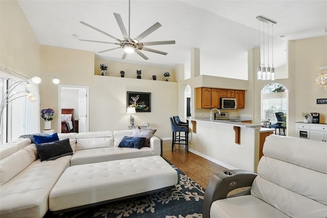 tiled living area with a ceiling fan and a towering ceiling