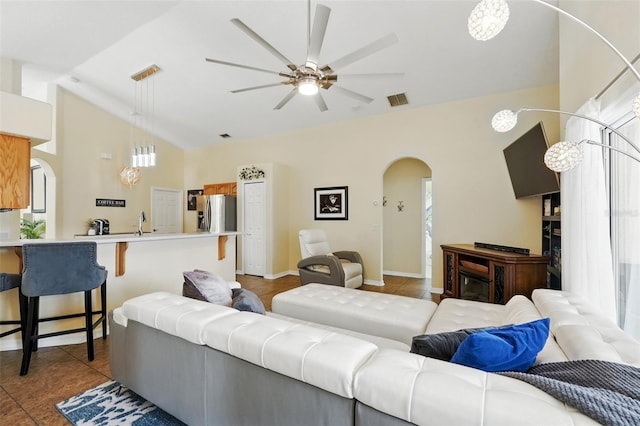 living area with arched walkways, a ceiling fan, visible vents, and plenty of natural light