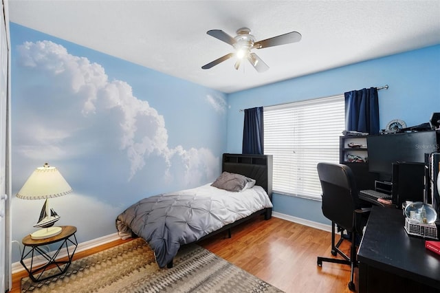 bedroom with a ceiling fan, baseboards, and wood finished floors