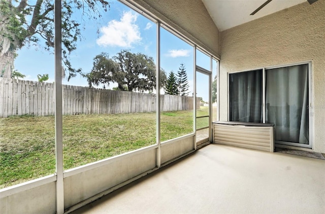 unfurnished sunroom featuring ceiling fan