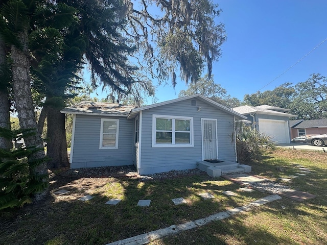 8702 El Portal Dr, Tampa, FL 33604 - view of front facade featuring an attached garage and a front yard
